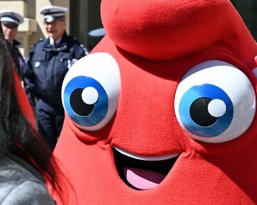 La mascotte des Jeux olympiques avec en arrière-plan, des policiers qui montent la garde. (Photo d'illustration: L.Picard / L'Essor)